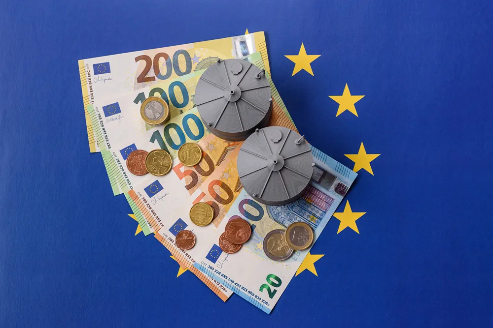 Avro banknotları ve madeni paraları, Avrupa Birliği yıldızları ve iki gri metal disk üzerinde sergileniyor