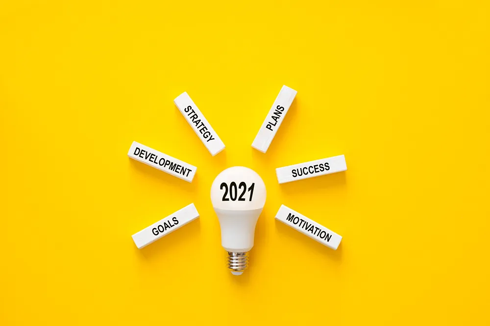 girişim (104) Üzerinde “2021” yazan ampulün çevresinde strateji, planlar, başarı, motivasyon, hedefler ve gelişim yazılı bloklar