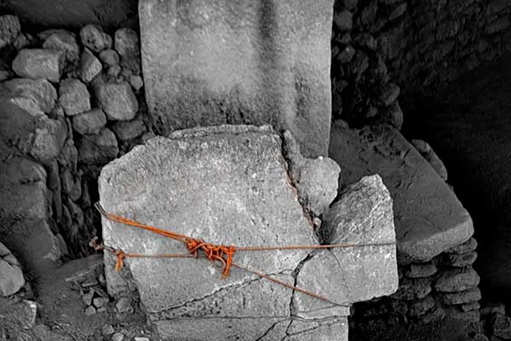 Taş bloklardan oluşan bir yapı kalıntısı, turuncu bir iple çevrelenmiş